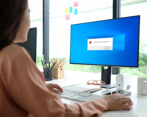 Mujer usando computadora con mensaje de error